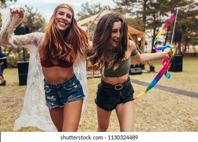 Hipster girls having fun at music festival outdoors. Two women enjoying at park during a summer festival.