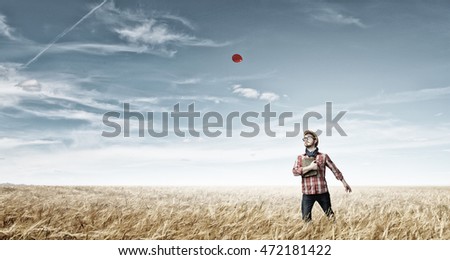 Similar – Junge Frau genießt den Tag auf einem Feld mit Grünflächen.