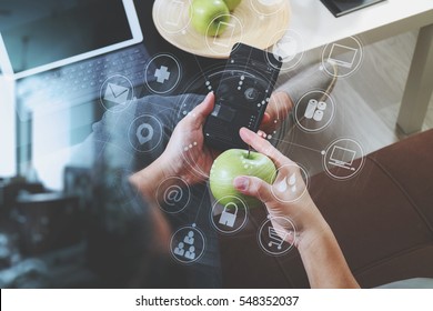 hipster hand using smart phone for mobile payments online business,omni channel,sitting on sofa in living room,green apples in wooden tray,virtual interface screen
