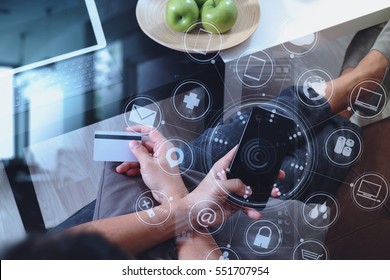 hipster hand using smart phone and laptop computer,holding credit card payments online business,sitting on sofa in living room,green apples in wooden tray,virtual interface screen
