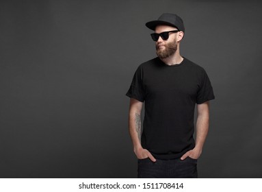 Hipster handsome male model with beard wearing black blank t-shirt with space for your logo or design