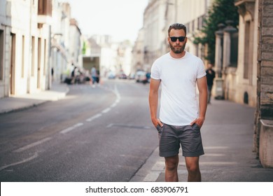 Hipster Handsome Male Model With Beard Wearing White Blank T-shirt With Space For Your Logo Or Design In Casual Urban Style