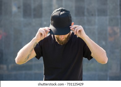 Hipster handsome male model with beard  wearing black blank  baseball cap  with space for your logo