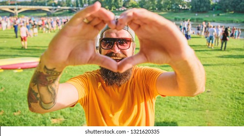 Hipster happy celebrate event picnic fest or festival. Cheerful fan love summer fest. Man bearded hipster in front of crowd people show heart gesture riverside background. Urban event celebration.