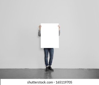 Hipster Holding Poster On Concrete Floor