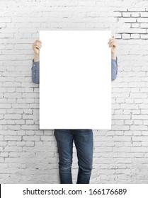 Hipster Holding Poster On Concrete Brick Wall