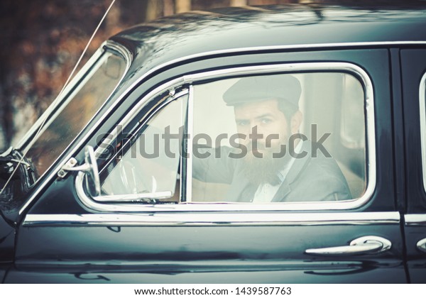 hipster look through window of retro car. hipster in\
vintage auto