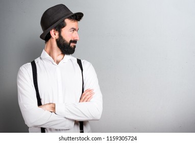 Hipster man with beard looking lateral on grey background