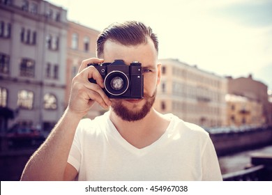 Hipster Man With A Camera In The City. Travel. Vintage Photo.