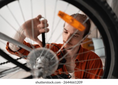 Hipster man in casual clothes repairing a bicycle wheel at home. mechanic working in bicycle home workshop