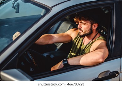 Hipster man driving a car on a sunny day. Sun in his eyes - Powered by Shutterstock