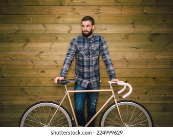 Hipster man with his fixie bike on a wooden background