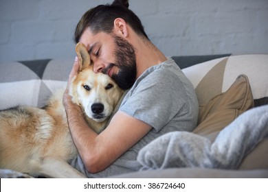 Hipster-Mann schnipst und umarmt seinen Hund, enge Freundschaft liebende Bindung zwischen Besitzer und Husky für Haustiere