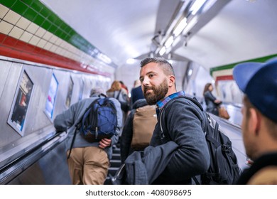 Hipster man standing at the escalator in London subway