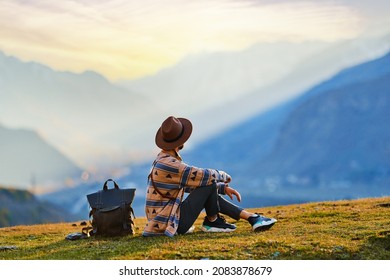 Hipster man traveler wanderer wearing hat sitting alone and enjoying freedom and calm inspired travelling  - Shutterstock ID 2083878679
