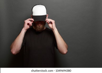 Hipster Man Walking Wearing Black Jeans, T-shirt And A White Baseball Cap