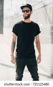 Hipster Man Walking Wearing Black Jeans, T-shirt And A Baseball Cap