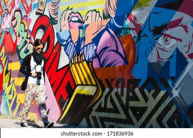 Hipster model walking next to a wall of graffiti in Brooklyn (NYC)