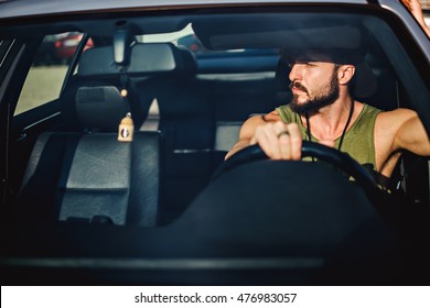 Hipster muscled man driving a car on a sunny day - Powered by Shutterstock