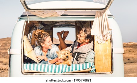 Pessoas hipster com cachorro fofo viajando juntos em uma minivan vintage - Conceito de inspiração para a vida e desejo de viajar com casal hippie em viagem de aventura de mini van - Filtro quente brilhante