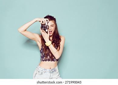 Hipster Photographer Fashion Stylish Woman Making Photo Using Retro Camera. Portrait On Blue Background 