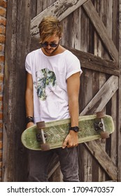 Hipster Style Guy. Young Skater Man With A Skateboard In Casual Wear