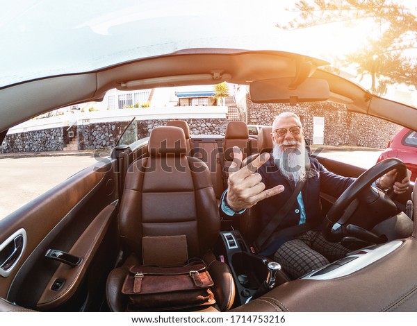 Hipster stylish man inside convertible car -\
Senior entrepreneur having fun with cabriolet auto - Fashion,\
elegant and business concept - Focus on\
face