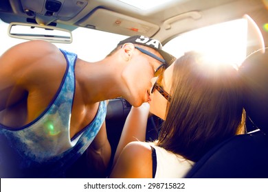 Hipster Teen Couple Looking Into Each Other's Eyes And Kissing.Sunshine Portrait,couple Sitting On Hood Of Their Car Enjoying The Moment,outdoors,couple On Glasses.Young Couple In Love On A Road Trip
