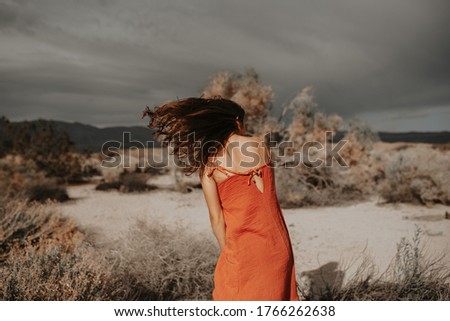 Hipster traveler girl with boho look and windy hair, in desert nature. Artistic photo of young hipster traveler girl in gypsy look, in Coachella Valley