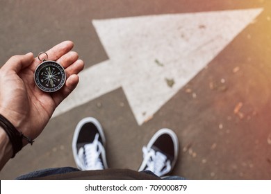 Hipster traveler holding compass in the hand making choice in what direction to go - Shutterstock ID 709000879
