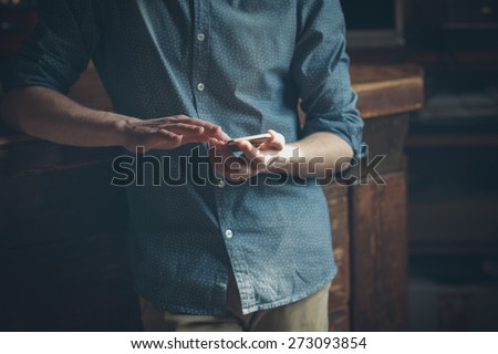 Hipster using a touch screen smart phone hands close up, vintage colors