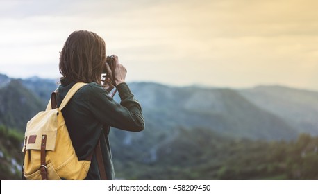 Hipster young girl with bright backpack taking photo of amazing landscape sunset on vintage camera on peak mountain mockup. Tourist traveler on background sunlight in trip in northern Spain  - Powered by Shutterstock