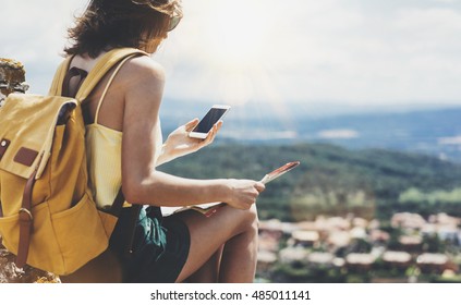 Hipster Young Girl With Bright Backpack Looking At Phone And Map. Said View Tourist Traveler On Background Mountain, Blue Sea, Sun Flare. Mockup For Text Message. Female Hands Using Smartphone