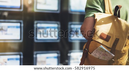 Hipster young man with backpack and map looking ad promo poster hotel, choose apartments. Tourist traveler planning route on background advert hostel city. Person hiker select hotel backdrop street