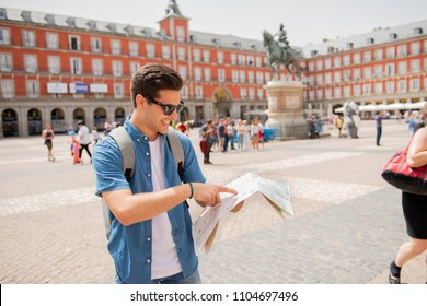 Hipster Young Man Traveler Traveling In Madrid Holing Up A Map In The Plaza Major In Tourist Travel Europe Concept