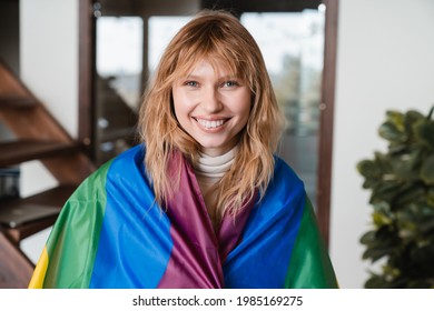 Hipster young woman lesbian female covering with LGBT flag. Sexual minorities rights. Free love for gays and lesbians. LGBT community. Rainbow flag for protest against inequality