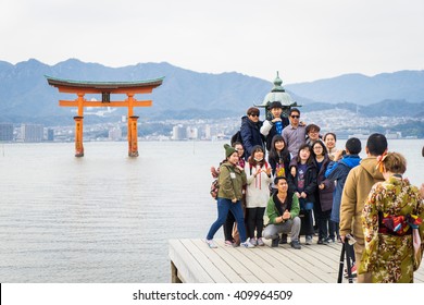 Hiroshima, Japan - March 16, 2016: Miyajima On March 16, 2016. A Large Group Of Tourists Is Taking Picture With The Famous Floating Tore.