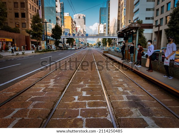 Hiroshima, Hiroshima Prefecture, Japan - October 9,\
2021: A view down the old cobblestone trolley tracks at a stop in\
the downtown area.