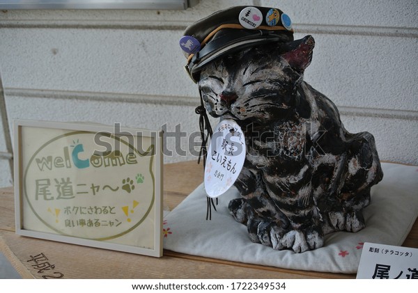 HIROSHIMA/JAPAN-May 15, 2013: The terra-cotta\
cat station master. (TRANSLATION: Welcome to Onomichi city, Meow.\
Touch me and you will get lucky / “Koiemon”, stationmaster, Senkoji\
ropeway).