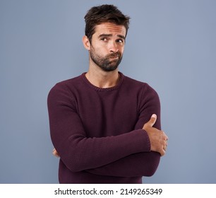 His Mind Is Going A Million Miles An Hour. Studio Shot Of A Handsome Young Man Looking Thoughtful Against A Gray Background.