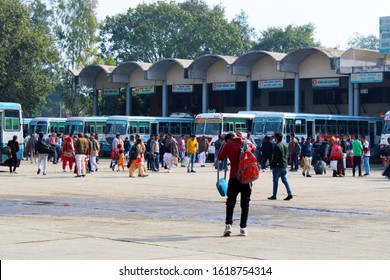 Hisar, Haryana, India - 14 January, 2020: Indian People Walk At The Bus Station Amid Parked Colorful Buses And Buildings