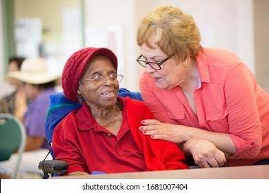 Hispanic and  African American women together in a busy senior center