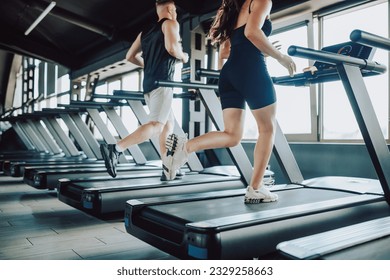 Hispanic and American Couple run treadmill Fitness in the Gym. Caucasian Man and Hispanic Woman Engaged in Intense Workout. Young Fit Couple Training Together at the Gym