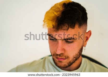 Hispanic bearded man with half dyed blonde hair
