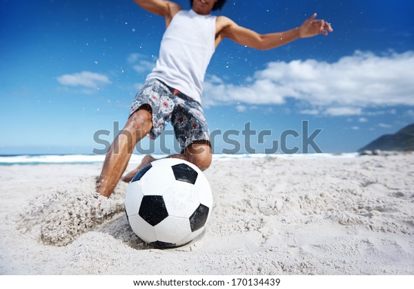 Hispanic Brasil man playing soccer on beach with\
dribble skill and ball on\
vacation