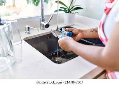 Hispanic Brunette Woman Washing Dishes At The Kitchen