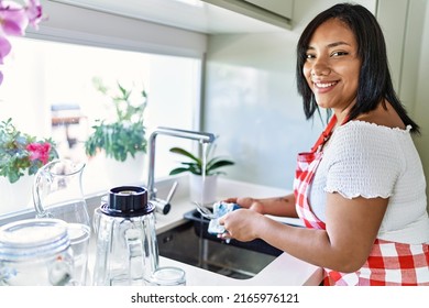 Hispanic Brunette Woman Washing Dishes At The Kitchen