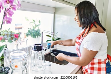 Hispanic Brunette Woman Washing Dishes At The Kitchen