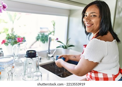 Hispanic Brunette Woman Washing Dishes At The Kitchen