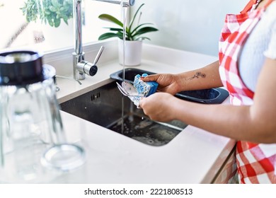 Hispanic Brunette Woman Washing Dishes At The Kitchen